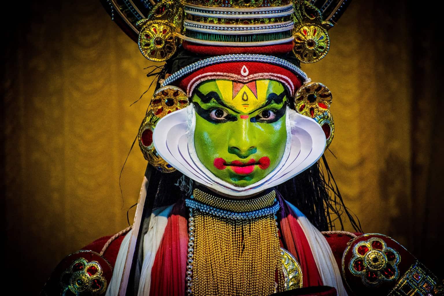 A Kathakali performer in green pacha make-up and a tall crown