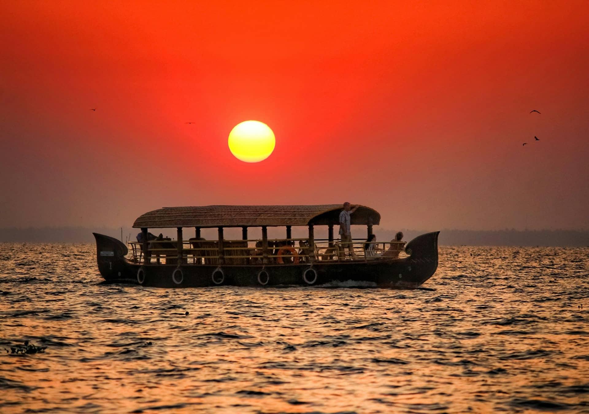 A houseboat silhouetted against the sunset at Kumarakom