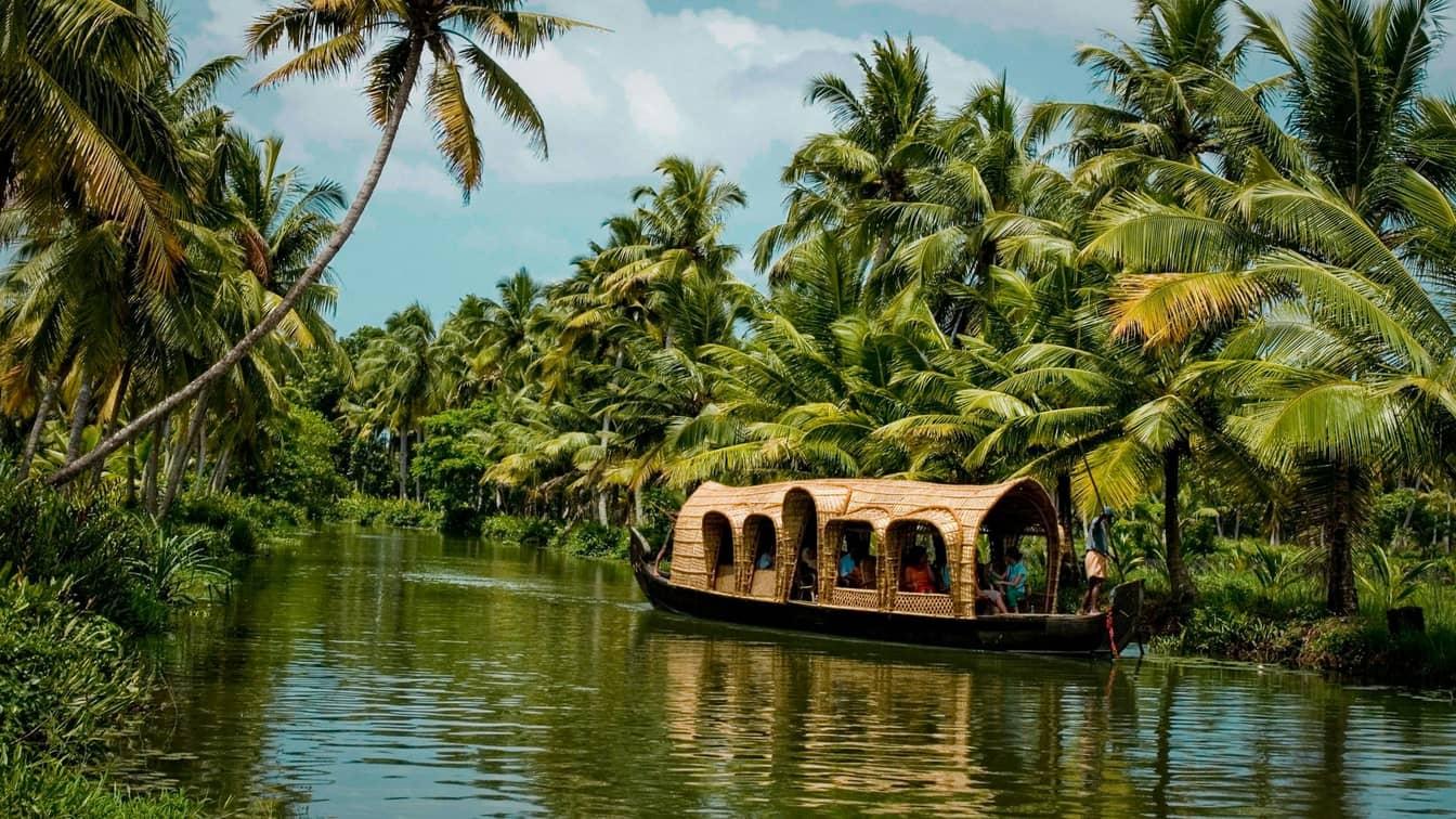 A houseboat on a palm-lined backwater canal in Kerala