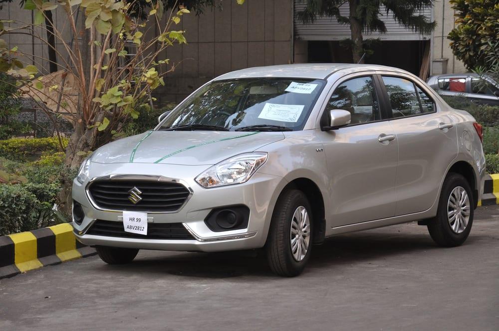 A silver Maruti Suzuki Dzire sedan